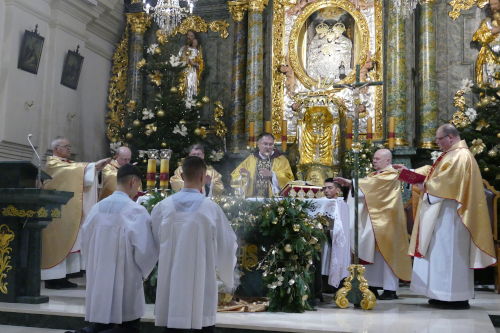 Szeciu Kapanw odmawiajcych modlitw eucharystyczn przy Otarzu. Przed Otarzem stoj dwaj ministranci z kadzidem.