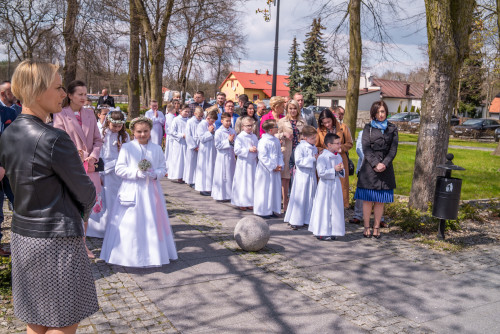 grupa dzieci w albach wraz z rodzicami stojca przed kocioem