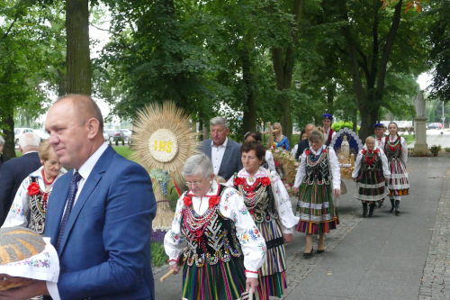 ludzie idcy do kocioa z wiecami oraz darami - ubrani w stroje ludowe oraz garnitury